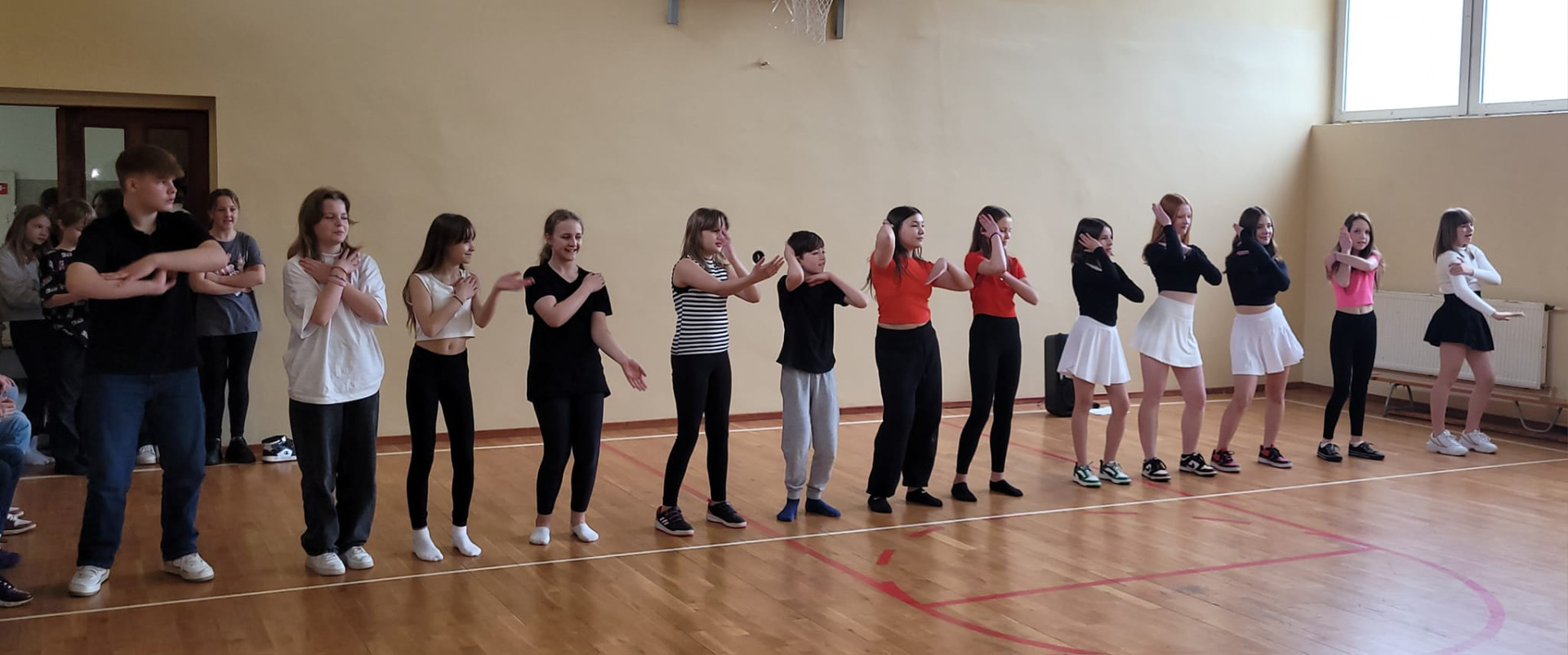 Uczniowie szkoły podczas prezentacji tańca na sali gimnastycznej.