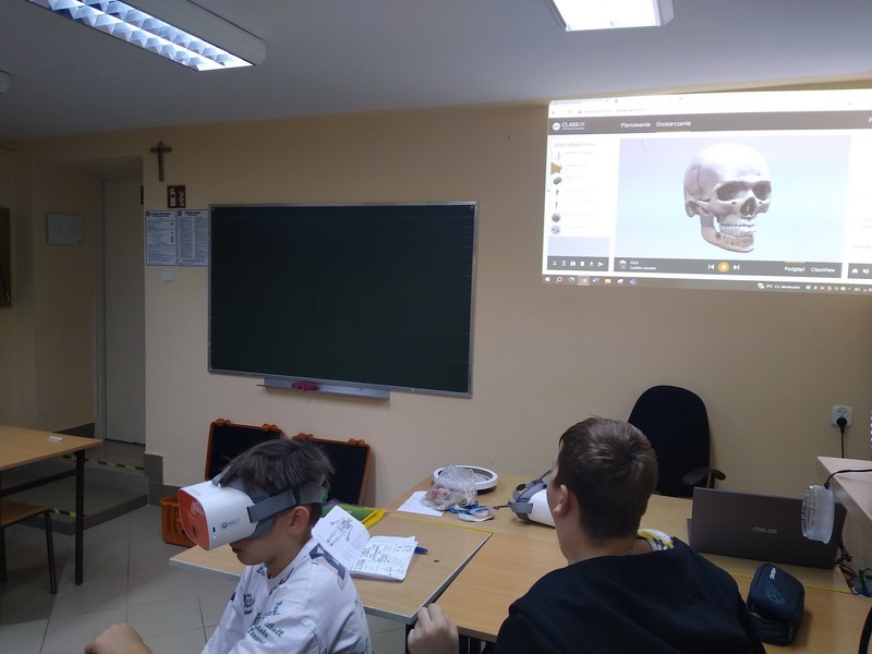 Uczniowie klasy 7 w okularach VR oglądają budowę czaszki.