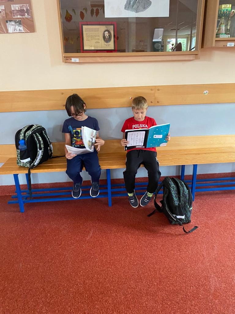 Chłopcy czytają książkę na ławce