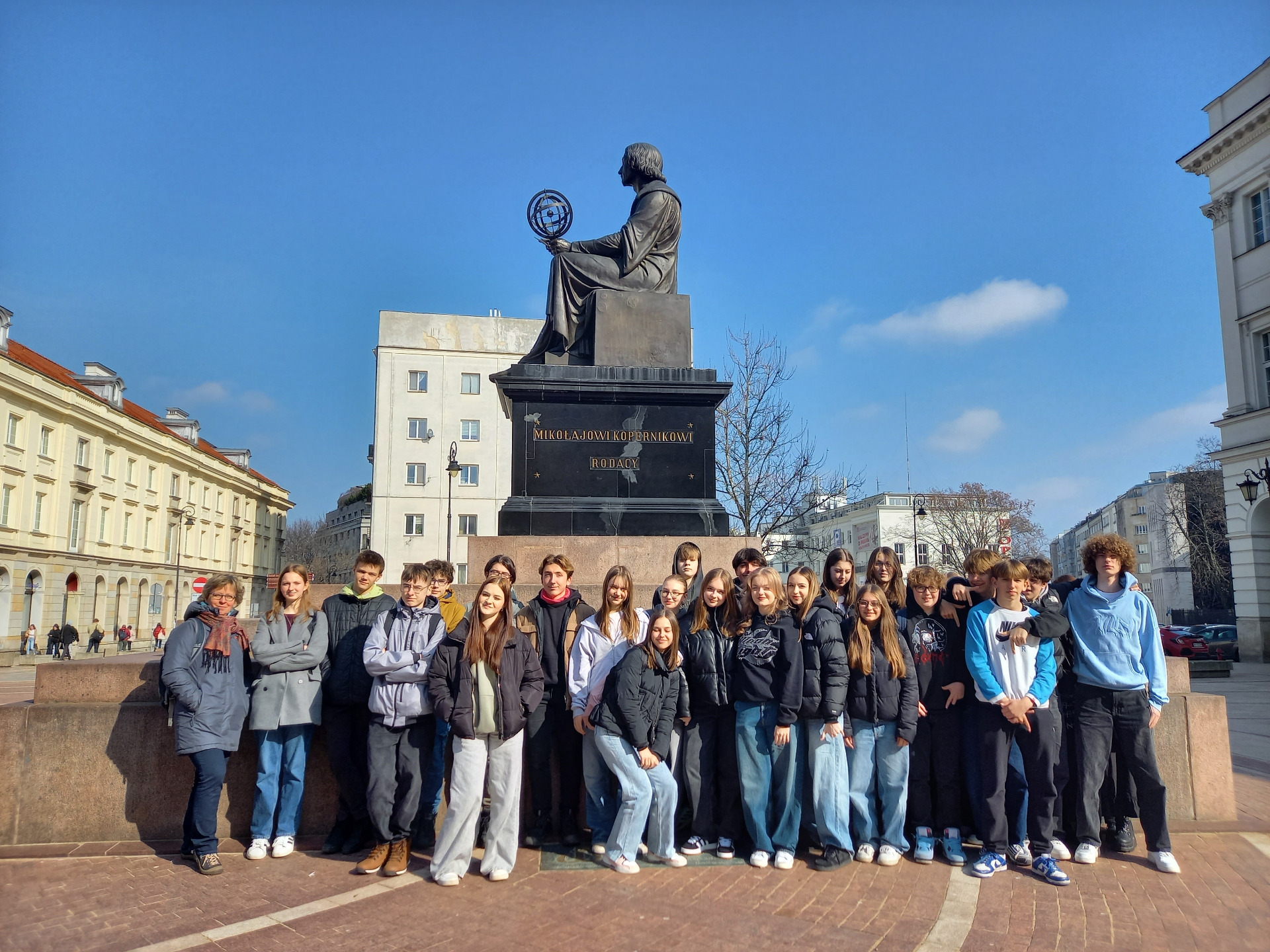 uczniowie przy pomniku Mikołaja Kopernika