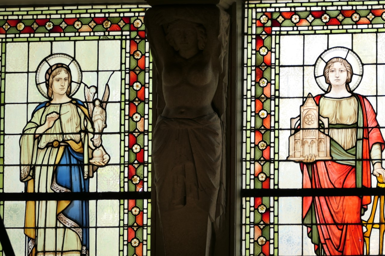 Na zdjęciu znajdują się dwa witraże oraz biała rzeźba nawiązujące do kolorów flagi Francji: białego, niebieskiego oraz czerwonego