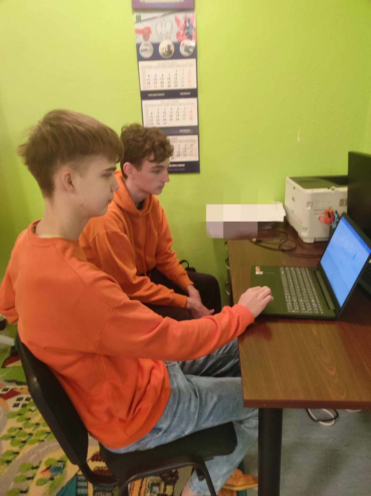Uczniowie piszą konkurs na komputerze.