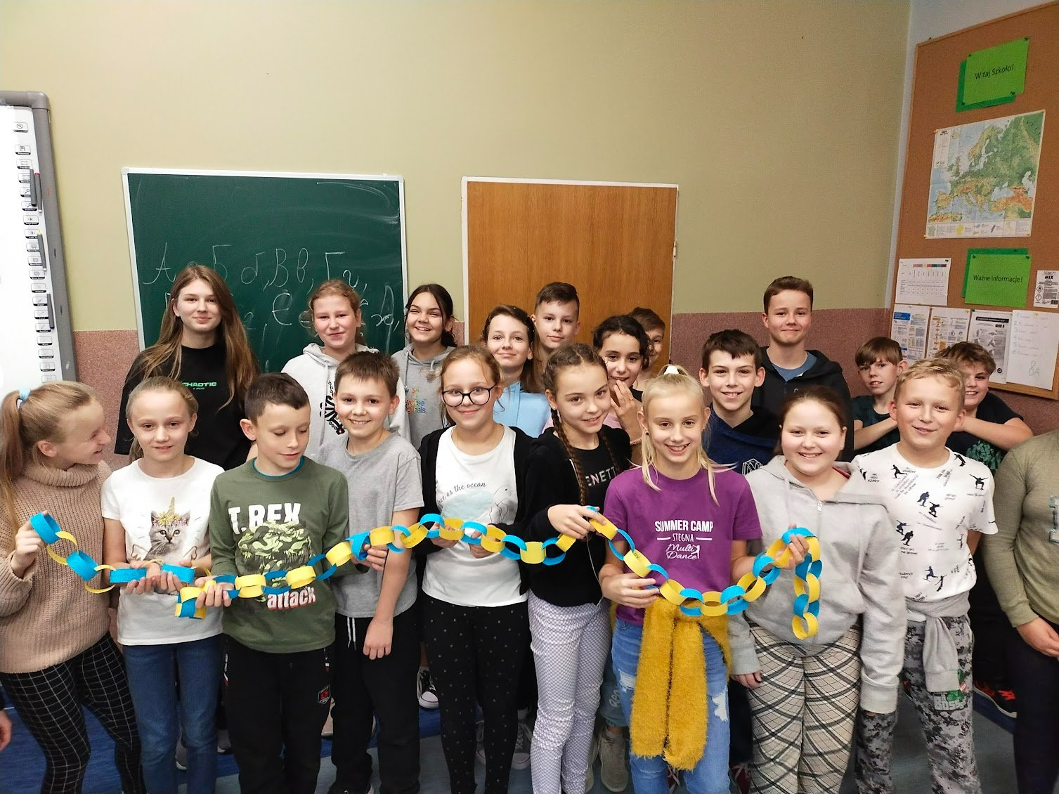 Uczniowie klasy 5 wraz z kolegami z Ukrainy trzymają łańcuch przyjaźni.