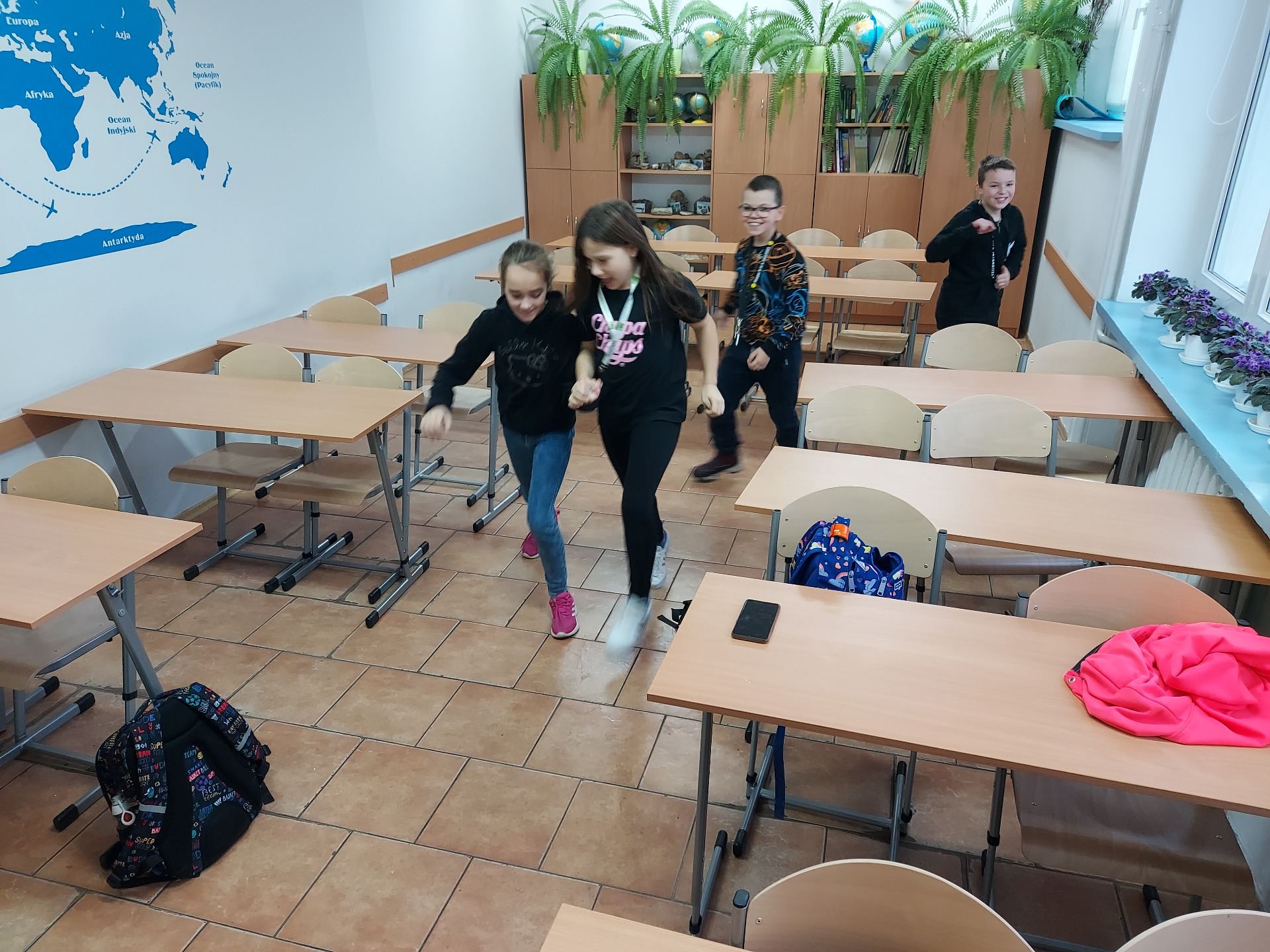 Uczniowie tańczą w sali lekcyjnej