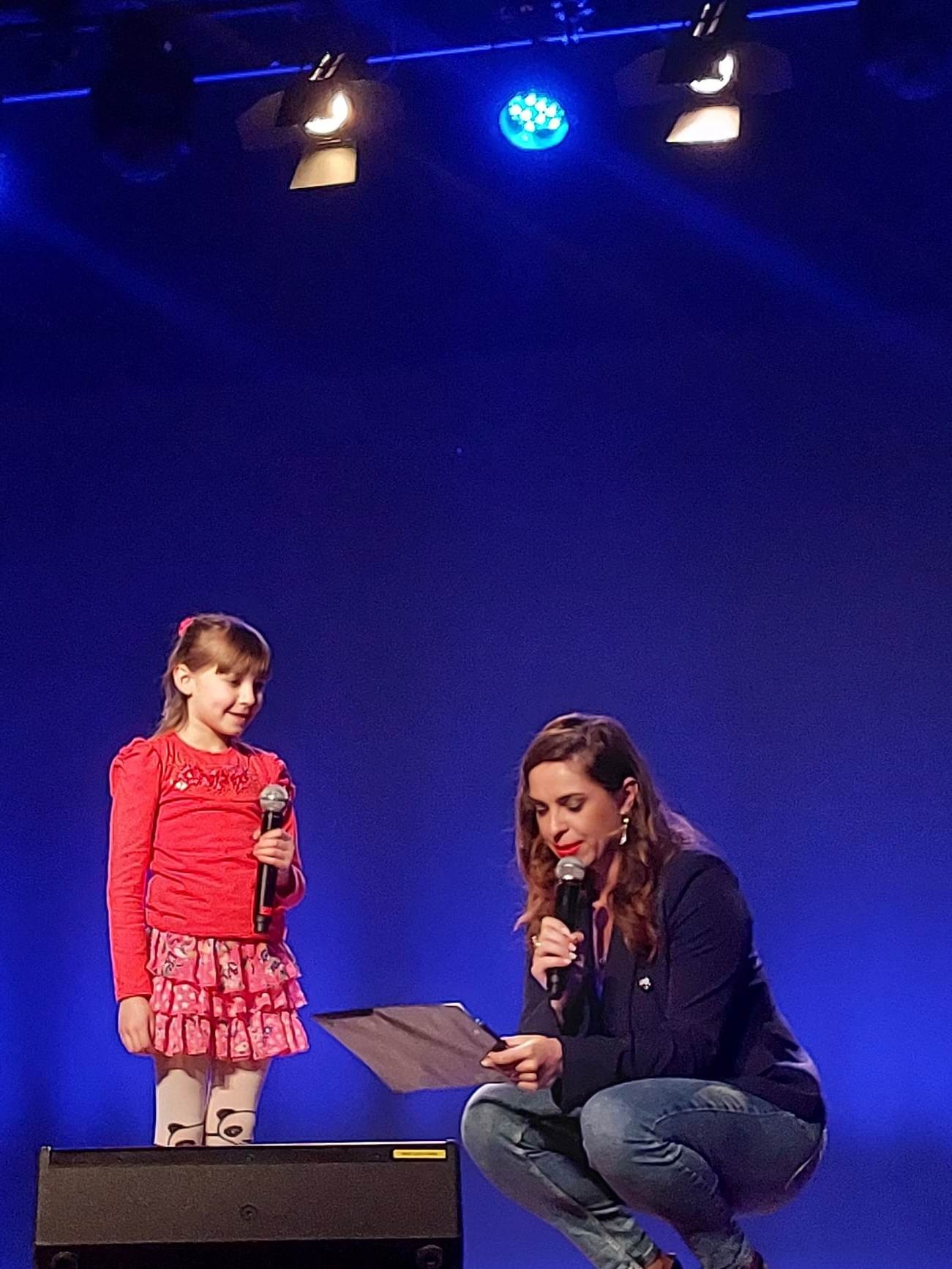 Dziewczynka oraz prowadząca konkurs na scenie 