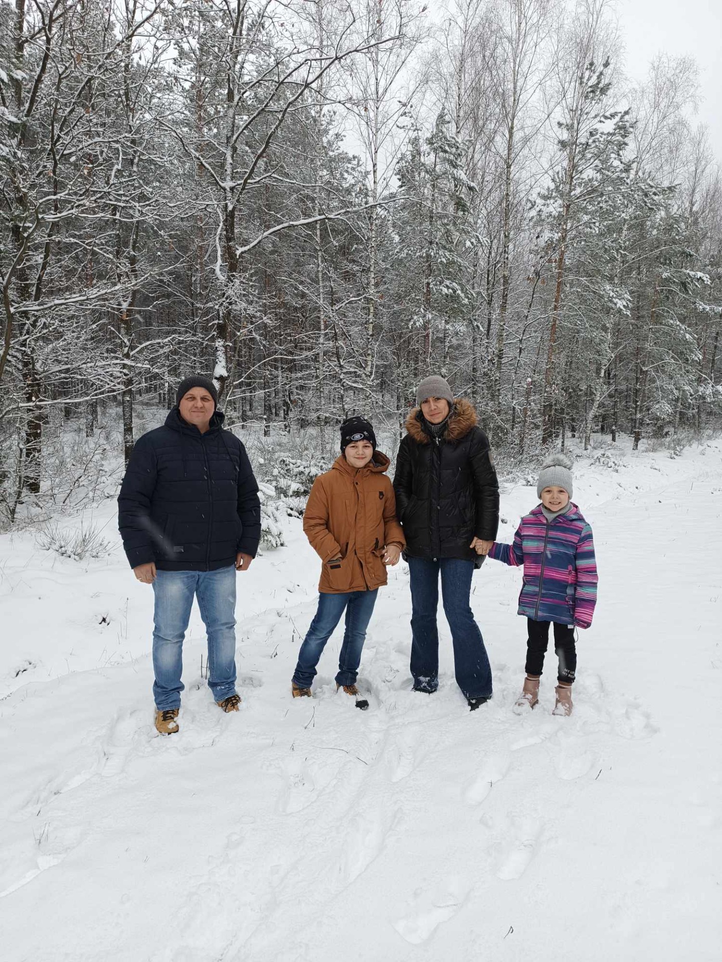 Wspólny spacer rodziców z dziećmi w zimowym plenerze
