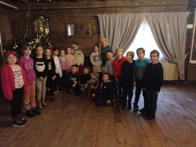 18 dzieci z klasy II z wychowawczynią, ustawieni przy Świętym Mikołaju.