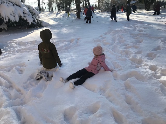 Dwoje dzieci bawi się na śniegu