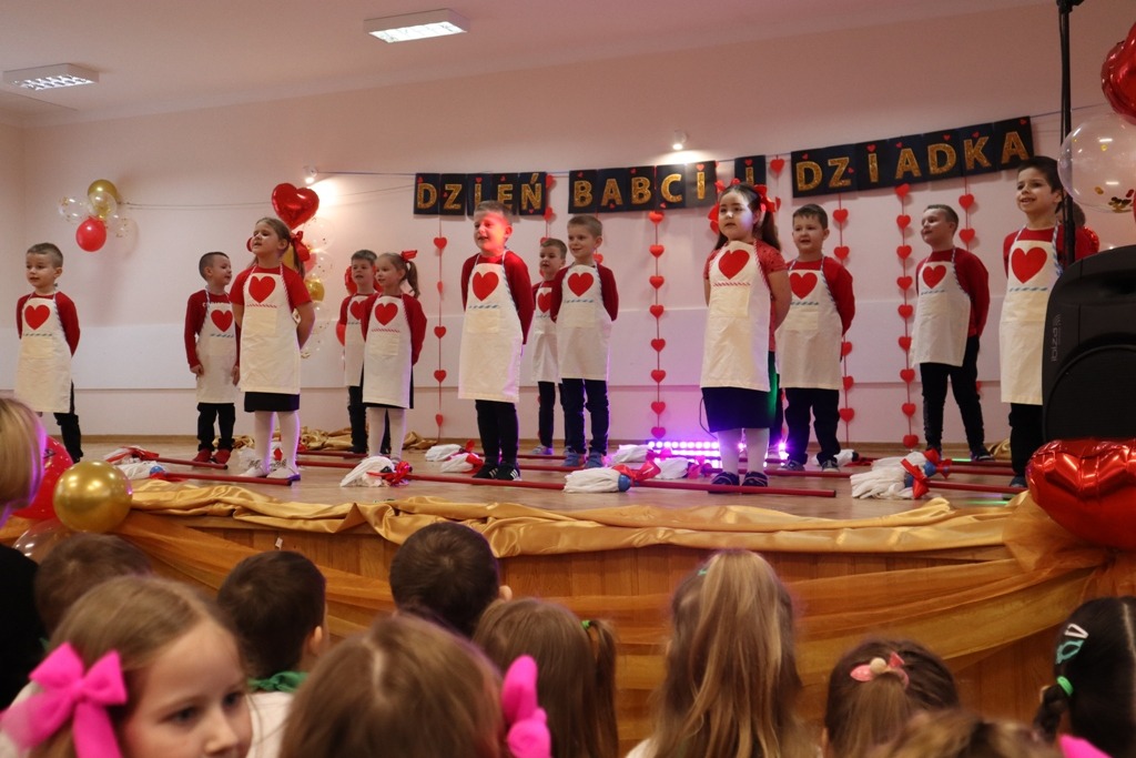 Zdjęcie przedstawia uczniów oddziału przedszkolnego - grupa "Skrzaty" podczas przedstawienia z okazji Dnia Babci i Dziadka.